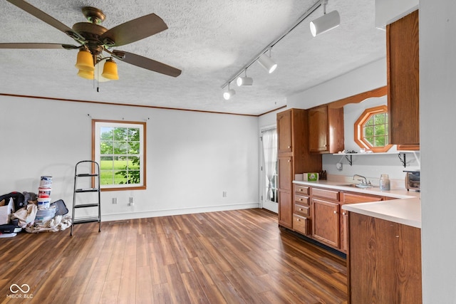 925 W Hancock Rd, Scottsburg, IN 47170 - kitchen featuring brown cabinetry, a textured ceiling, light countertops, dark wood-type flooring, and a ceiling fan