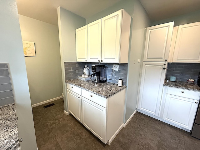 729 Maple Ln, Brownsburg, IN 46112 - kitchen featuring backsplash, dark stone countertops, and white cabinetry