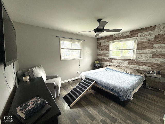 729 Maple Ln, Brownsburg, IN 46112 - bedroom featuring wooden walls, an accent wall, multiple windows, ceiling fan, and wood finished floors