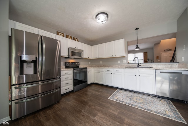 4238 Victory Ct, Indianapolis, IN 46203 - kitchen featuring stainless steel appliances, dark wood-style floors, light stone countertops, a textured ceiling, and white cabinets