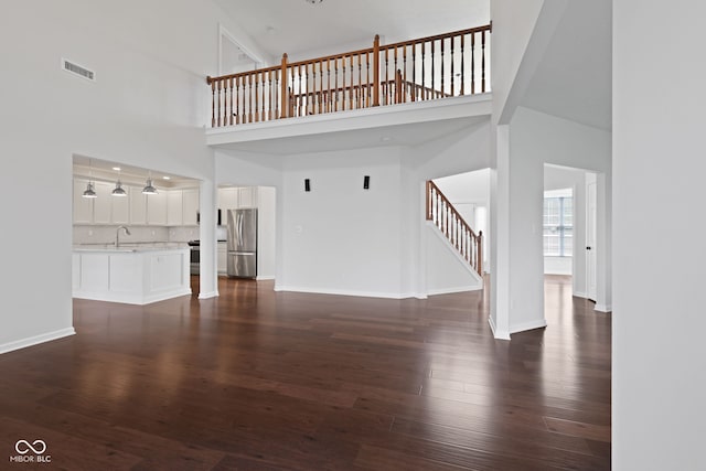 2078 Seneca Ln, Plainfield, IN 46168 - unfurnished living room with a high ceiling, stairs, and dark wood-style flooring