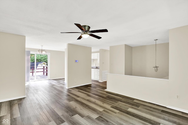 8920 Caminito Rd, Indianapolis, IN 46234 - unfurnished living room featuring a chandelier, a ceiling fan, and dark wood-style flooring