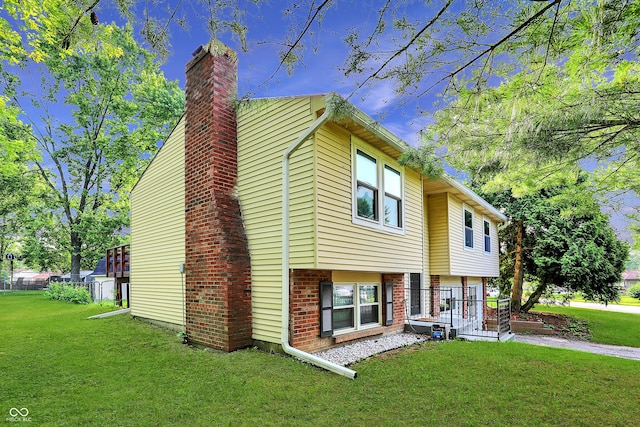 8920 Caminito Rd, Indianapolis, IN 46234 - view of front of home featuring a chimney, a front lawn, and brick siding