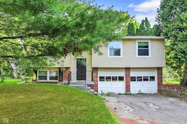 8920 Caminito Rd, Indianapolis, IN 46234 - split foyer home featuring an attached garage, a front yard, brick siding, and asphalt driveway