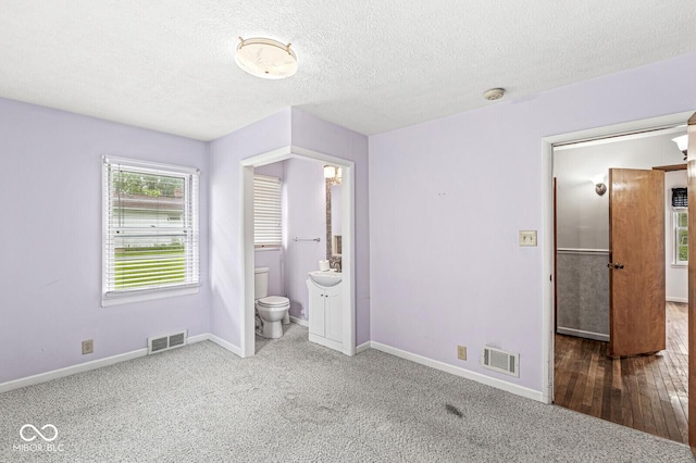 4010 S Bazil Ave, Indianapolis, IN 46239 - unfurnished bedroom featuring a textured ceiling, carpet floors, and connected bathroom