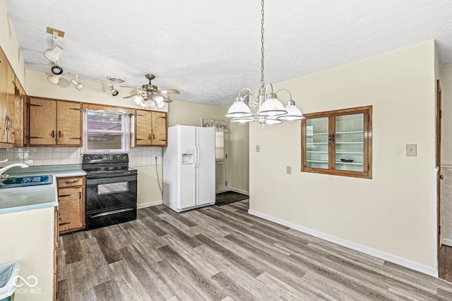 4010 S Bazil Ave, Indianapolis, IN 46239 - kitchen with black / electric stove, white fridge with ice dispenser, dark wood-style floors, brown cabinetry, and a textured ceiling