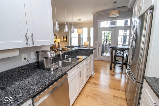 355 E Ohio St Unit 211, Indianapolis, IN 46204 - kitchen with appliances with stainless steel finishes, light wood finished floors, white cabinets, hanging light fixtures, and crown molding