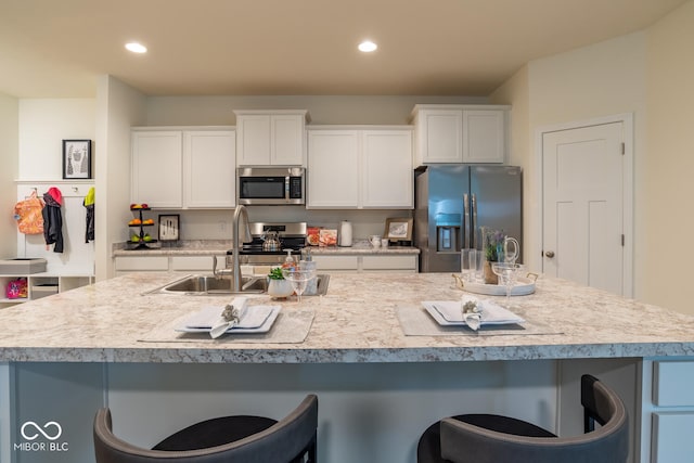 3541 N Hackberry St N, Bloomington, IN 47404 - kitchen with stainless steel appliances, a breakfast bar, white cabinetry, light countertops, and recessed lighting