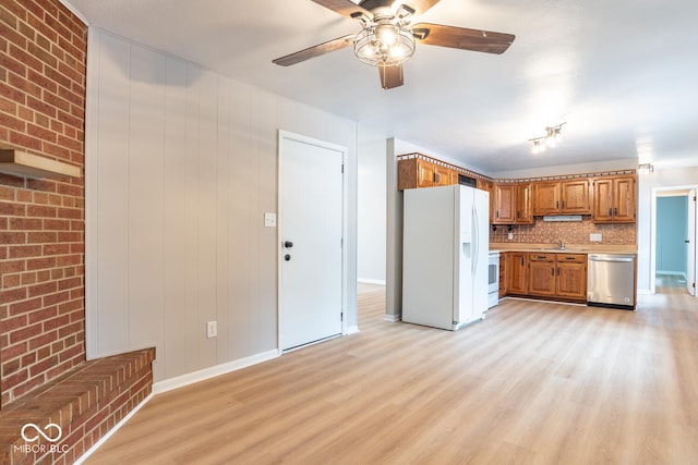 3212 S Fairington Dr, Bloomington, IN 47403 - kitchen with white appliances, brown cabinets, light countertops, light wood-style flooring, and brick wall