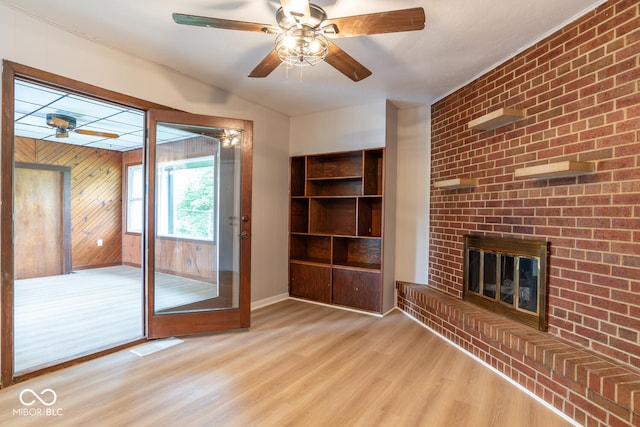 3212 S Fairington Dr, Bloomington, IN 47403 - unfurnished living room featuring wood finished floors, a fireplace, a ceiling fan, and wooden walls