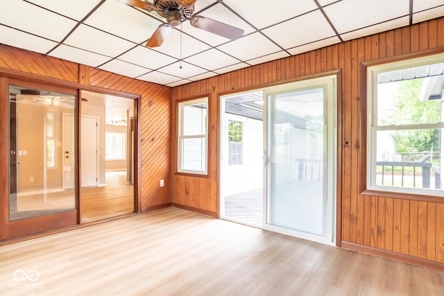 3212 S Fairington Dr, Bloomington, IN 47403 - unfurnished room featuring ceiling fan, plenty of natural light, light wood-type flooring, wood walls, and a drop ceiling