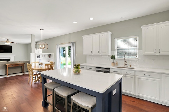 13191 Roma, Carmel, IN 46074 - kitchen featuring ceiling fan, tasteful backsplash, a fireplace, a kitchen island, and white cabinetry