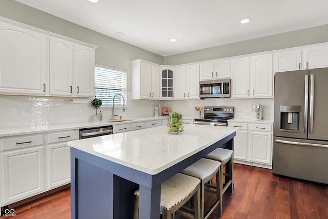 13191 Roma, Carmel, IN 46074 - kitchen featuring appliances with stainless steel finishes, a breakfast bar, tasteful backsplash, recessed lighting, and white cabinetry