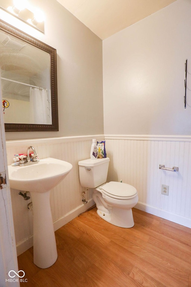 982 Ramsgate Rd, Greenwood, IN 46143 - bathroom with wood finished floors, a wainscoted wall, and a shower with shower curtain