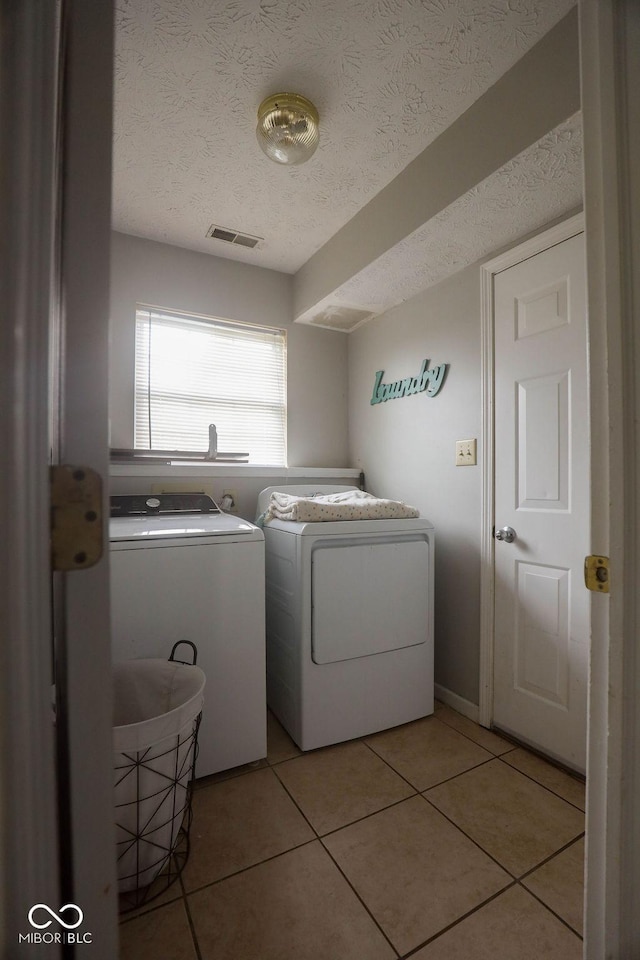982 Ramsgate Rd, Greenwood, IN 46143 - washroom featuring independent washer and dryer, light tile patterned floors, and a textured ceiling