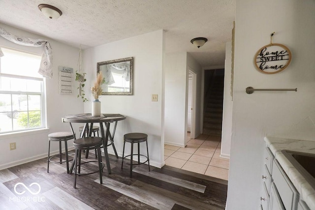 982 Ramsgate Rd, Greenwood, IN 46143 - dining room featuring light wood finished floors, a textured ceiling, and stairs