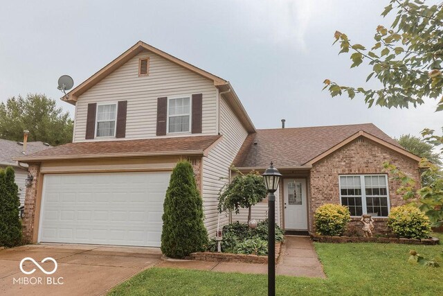 982 Ramsgate Rd, Greenwood, IN 46143 - traditional-style home with an attached garage, driveway, a front lawn, and a shingled roof