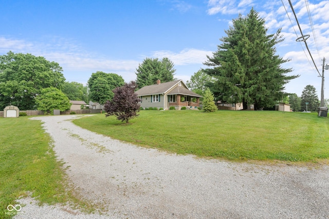 2211 S Andrews Rd, Yorktown, IN 47396 - view of front of house featuring a storage unit, driveway, a front yard, and a chimney