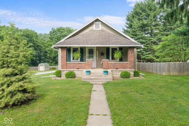 2211 S Andrews Rd, Yorktown, IN 47396 - bungalow-style house featuring a storage shed, covered porch, roof with shingles, and brick siding