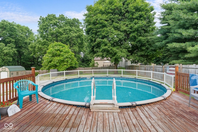 2211 S Andrews Rd, Yorktown, IN 47396 - view of pool with a wooden deck, a fenced backyard, a storage shed, and view of wooded area
