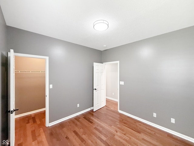 9302 N Bayland Dr, Mccordsville, IN 46055 - unfurnished bedroom with wood finished floors, a spacious closet, and a closet