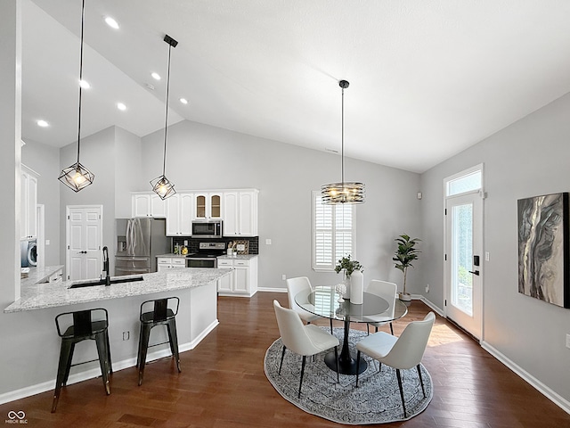 9302 N Bayland Dr, Mccordsville, IN 46055 - dining room with dark wood-style flooring, high vaulted ceiling, a chandelier, washer / clothes dryer, and recessed lighting