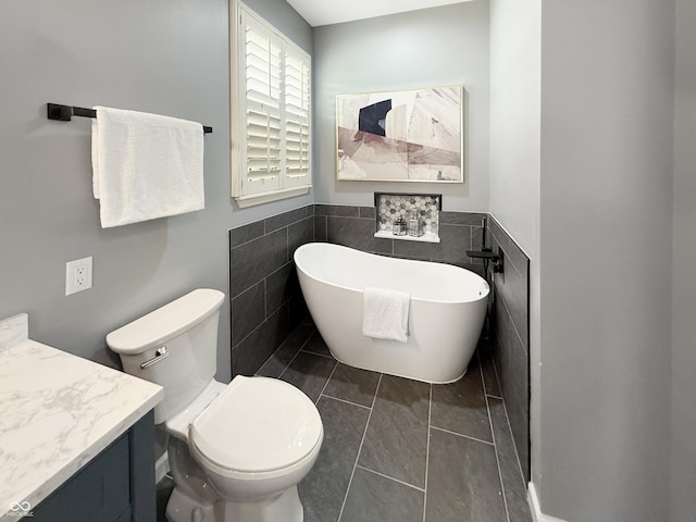 9302 N Bayland Dr, Mccordsville, IN 46055 - bathroom with a freestanding bath, vanity, tile walls, and wainscoting