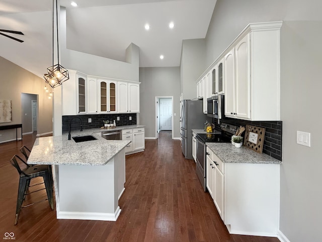 9302 N Bayland Dr, Mccordsville, IN 46055 - kitchen featuring stainless steel appliances, a peninsula, glass insert cabinets, a kitchen bar, and white cabinets