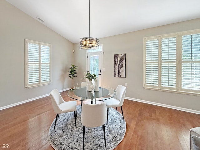 9302 N Bayland Dr, Mccordsville, IN 46055 - dining area with a chandelier, wood finished floors, and lofted ceiling