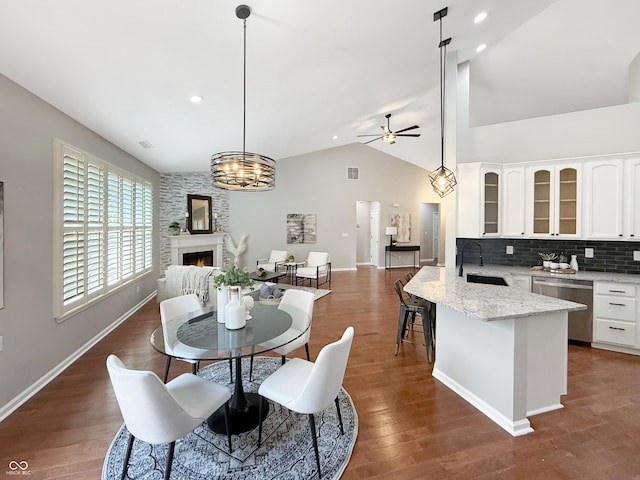 9302 N Bayland Dr, Mccordsville, IN 46055 - dining room with lofted ceiling, a fireplace, a ceiling fan, dark wood-type flooring, and recessed lighting