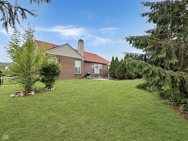9302 N Bayland Dr, Mccordsville, IN 46055 - rear view of house featuring a lawn, a chimney, and brick siding