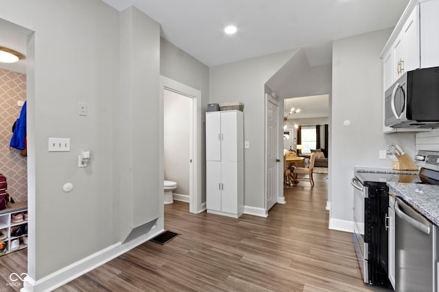 3045 Ruckle St, Indianapolis, IN 46205 - kitchen featuring stainless steel appliances, light wood-style floors, light stone countertops, white cabinets, and recessed lighting