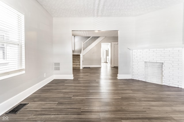 3045 Ruckle St, Indianapolis, IN 46205 - unfurnished living room featuring a textured ceiling, stairs, and dark wood-style flooring