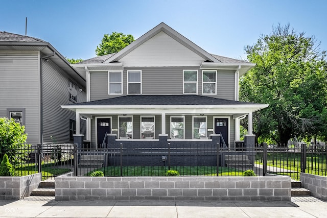 3045 Ruckle St, Indianapolis, IN 46205 - american foursquare style home with covered porch, a shingled roof, and a fenced front yard