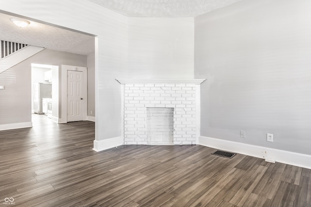 3045 Ruckle St, Indianapolis, IN 46205 - unfurnished living room with a textured ceiling, dark wood finished floors, and a fireplace