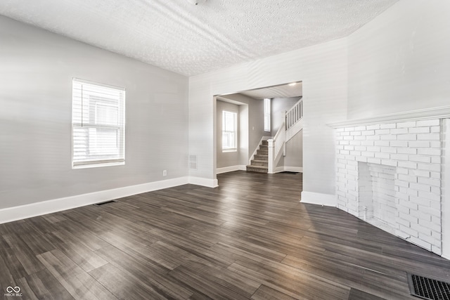 3045 Ruckle St, Indianapolis, IN 46205 - unfurnished living room with a textured ceiling, stairway, and dark wood finished floors