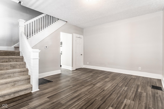 3045 Ruckle St, Indianapolis, IN 46205 - unfurnished living room with dark wood-style floors, stairs, and a textured ceiling