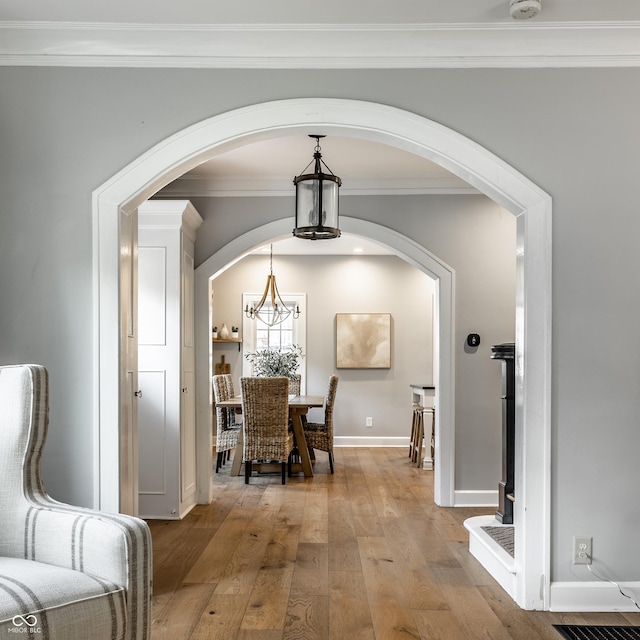 5760 Central Ave N, Indianapolis, IN 46220 - dining area with wood-type flooring, arched walkways, ornamental molding, and a chandelier