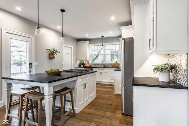 5760 Central Ave N, Indianapolis, IN 46220 - kitchen with appliances with stainless steel finishes, a breakfast bar, white cabinets, recessed lighting, and decorative backsplash