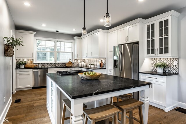 5760 Central Ave N, Indianapolis, IN 46220 - kitchen featuring stainless steel appliances, recessed lighting, white cabinetry, a breakfast bar, and tasteful backsplash