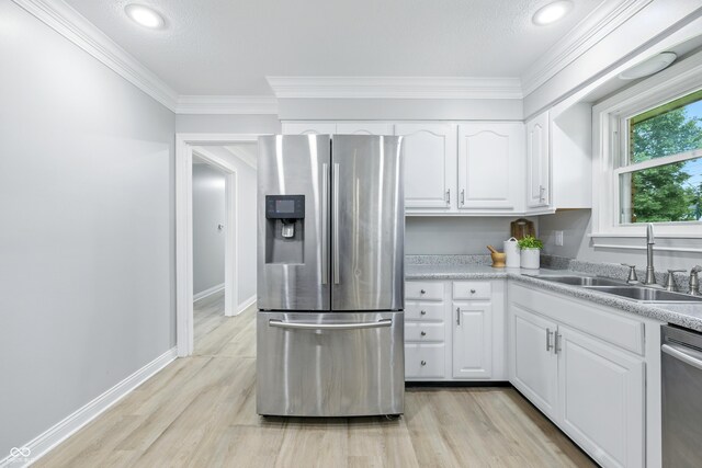 5205 Staughton Dr, Indianapolis, IN 46226 - kitchen with appliances with stainless steel finishes, light wood finished floors, crown molding, white cabinets, and light countertops