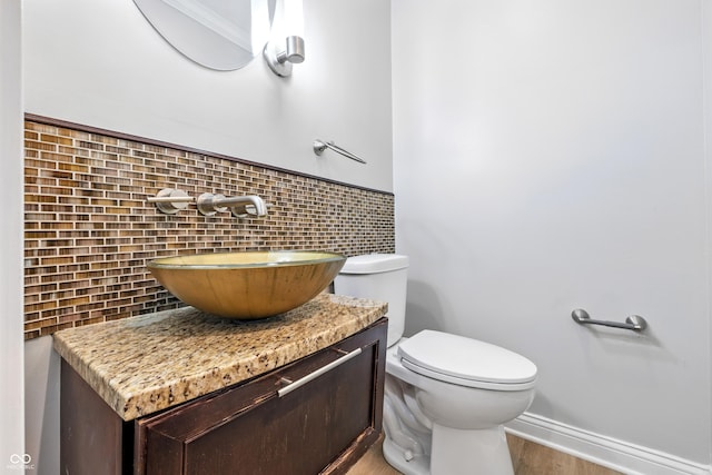 5205 Staughton Dr, Indianapolis, IN 46226 - half bath featuring vanity, tasteful backsplash, and wood finished floors
