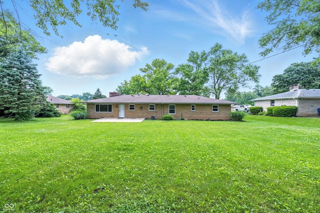5205 Staughton Dr, Indianapolis, IN 46226 - rear view of property featuring a patio area, a chimney, and a yard