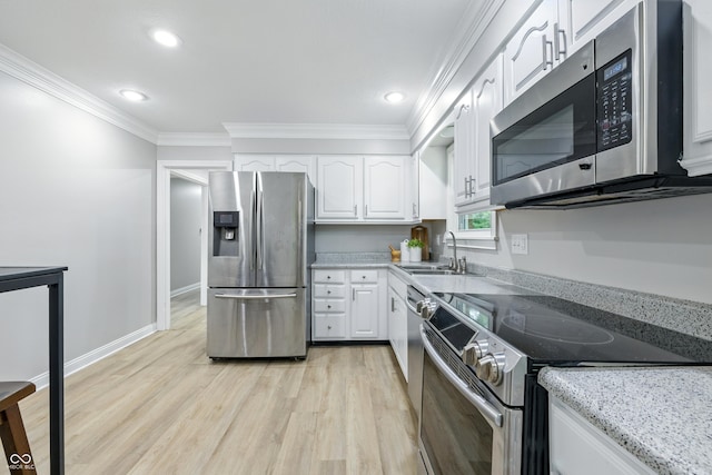 5205 Staughton Dr, Indianapolis, IN 46226 - kitchen featuring stainless steel appliances, white cabinetry, light wood-style flooring, crown molding, and light stone counters
