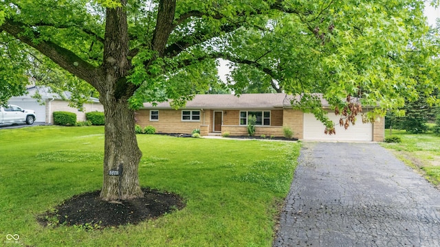 5205 Staughton Dr, Indianapolis, IN 46226 - ranch-style home featuring an attached garage, a front yard, brick siding, and asphalt driveway