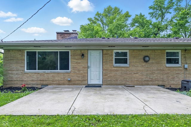 5205 Staughton Dr, Indianapolis, IN 46226 - back of property featuring a patio, a chimney, and brick siding