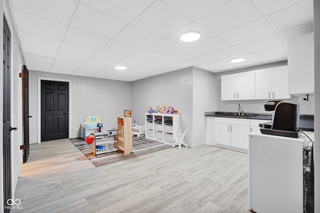 2384 Fairfax Dr, Columbus, IN 47203 - kitchen with dark countertops, light wood-style flooring, a drop ceiling, and white cabinets
