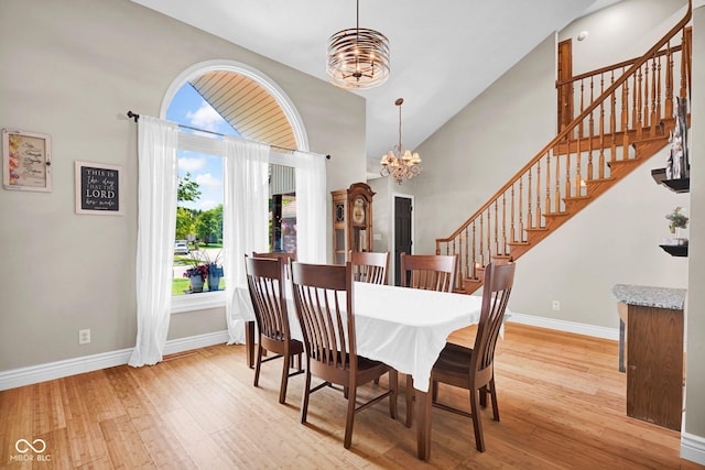 2384 Fairfax Dr, Columbus, IN 47203 - dining area featuring a chandelier, stairs, wood finished floors, and high vaulted ceiling
