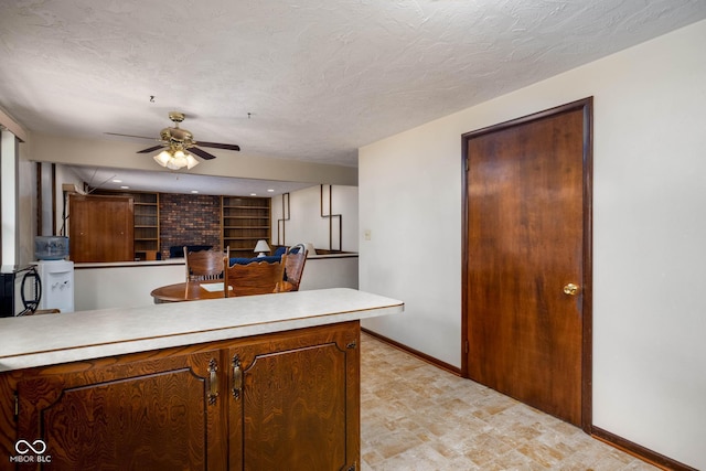 5749 Teresa Dr, Alexandria, IN 46001 - kitchen with a ceiling fan, a peninsula, light countertops, and a fireplace