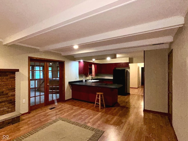 7721 Hollybrook Ln, Indianapolis, IN 46227 - kitchen featuring french doors, wood finished floors, dark countertops, beamed ceiling, and a peninsula